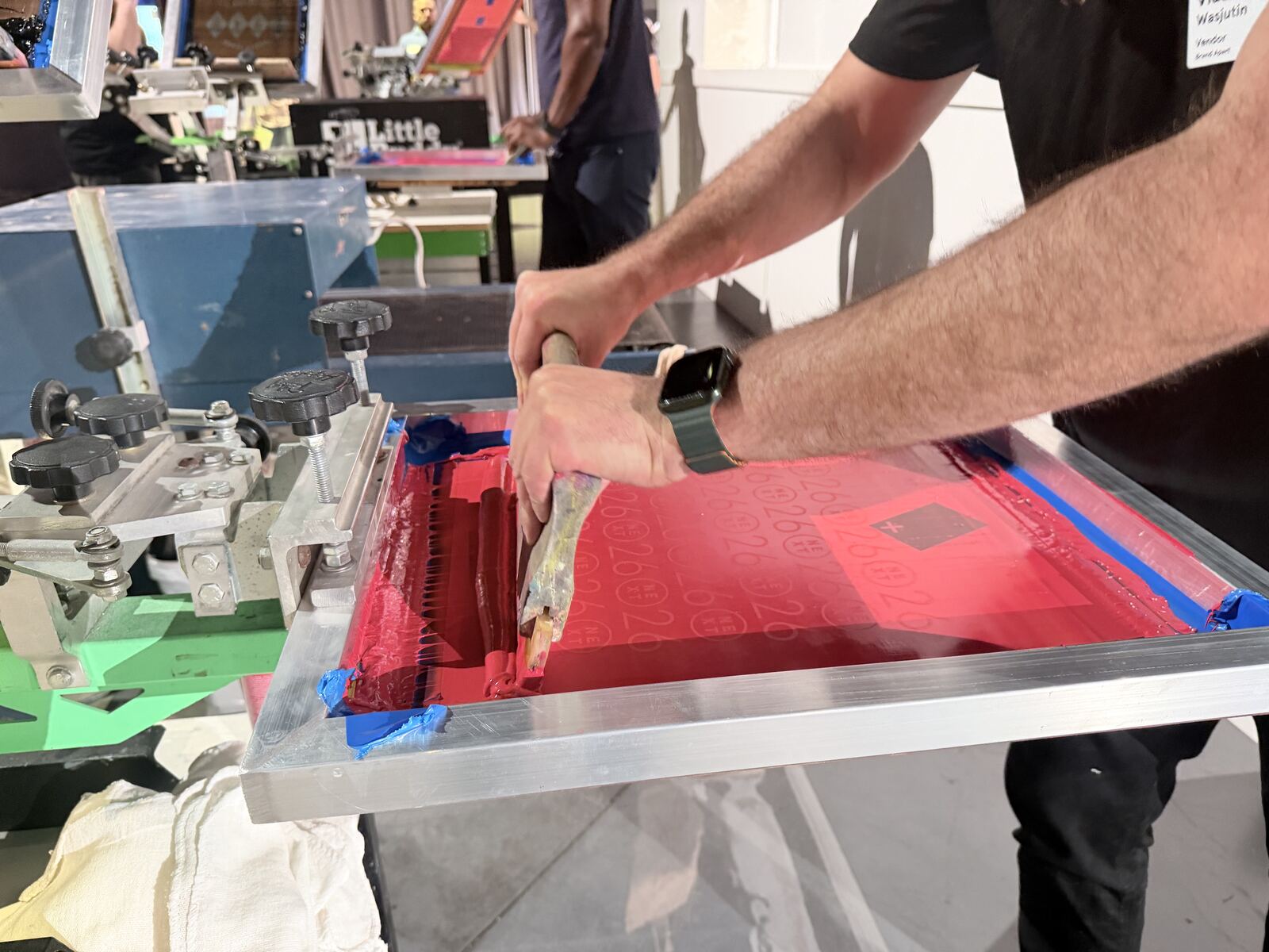 Live heat press demonstration with an operator's hands positioning apparel on professional equipment
